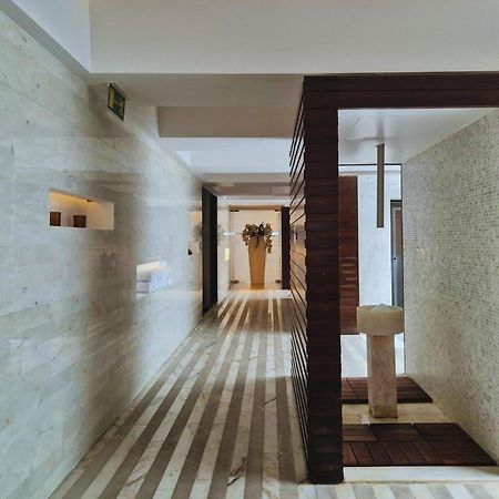 Vip Grand Lisboa Hotel & Spa Exterior photo The photo depicts a modern interior space, likely in a hotel or spa. It features a long, narrow hallway with minimalist design elements. The walls are a light-colored stone, and there are wooden features creating contrasts. 

The floor is designed wi